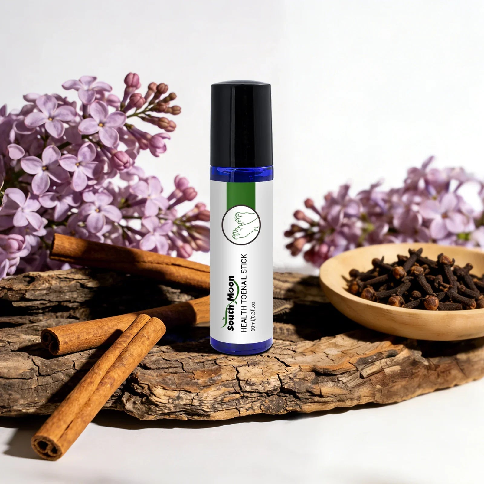 Herbal toenail treatment stick with lilac flowers, cinnamon sticks, and cloves on wood